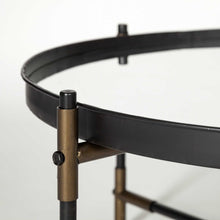 Mesa decorativa redonda con parte superior de espejo y base de metal negro y latón