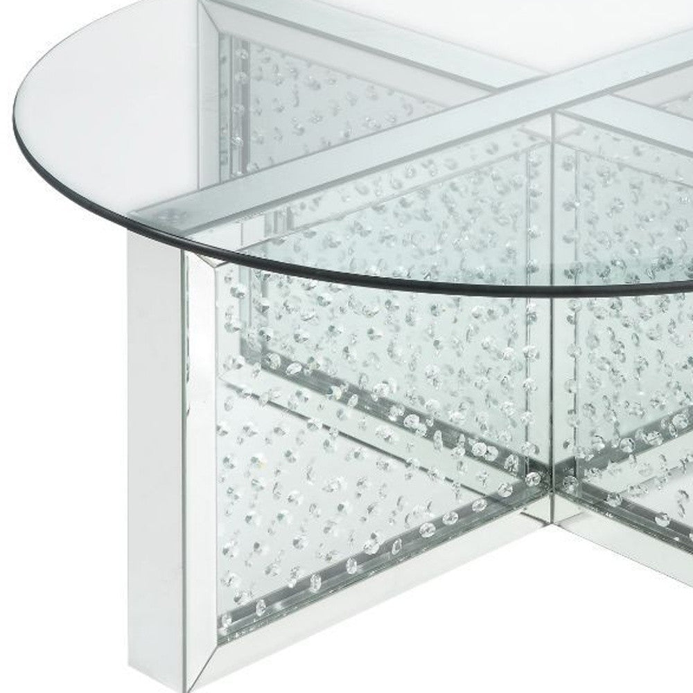 Mesa de centro con base brillante y parte superior redonda plateada y de vidrio transparente de 40"