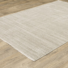 6' X 9' Ivory Beige Taupe And Tan Geometric Power Loom Stain Resistant Area Rug With Fringe